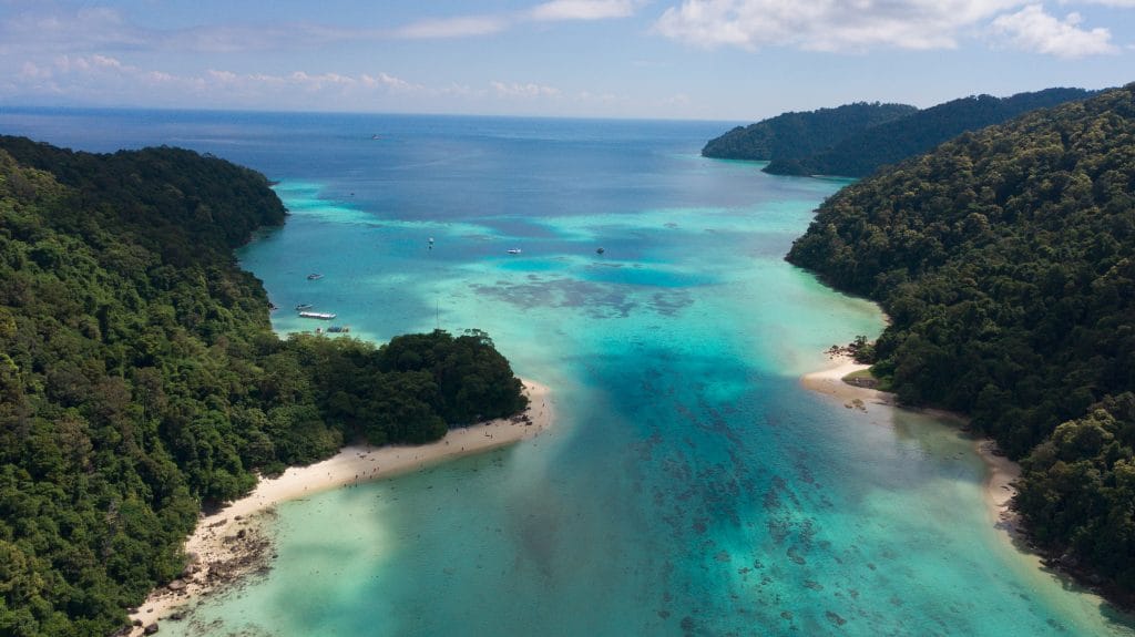 Aerial view of a turquoise channel between forested islands in Mu Ko Surin National Park
